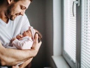 Papá alzando su bebé y revisando los granito de su cara