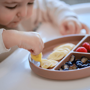 Un niño disfrutando de frutas frescas.