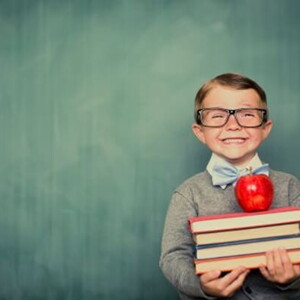 Niño sonriendo con libros en la mano.