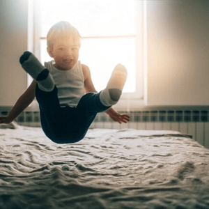 niño saltando sobre la cama