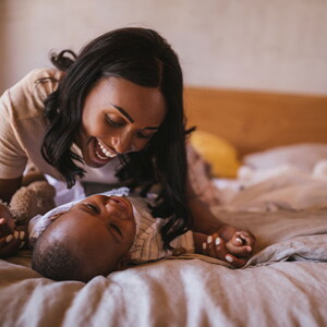 La mamá y el bebé haciendo ejercicios en la cama