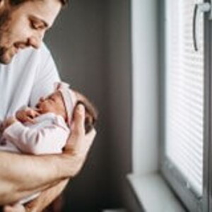 Papá alzando su bebé y revisando los granito de su cara