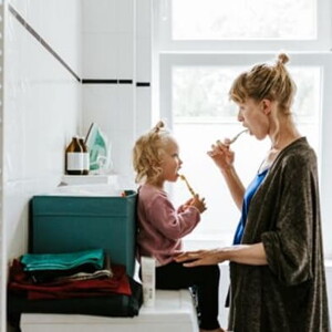 Mamá y niña en el baño cepillándose en el baño.