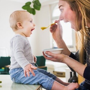 Mamá alimentando a su hijo con una papilla.