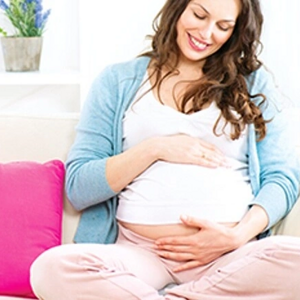 Imagen de una madre soltera cariñosamente tocando su barriga durante el embarazo