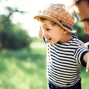 Niño haciendo equilibrio con su padre.