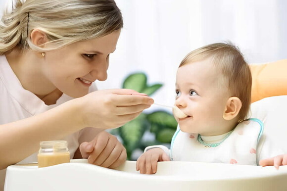 Mamá alimentando a su bebé en su silla