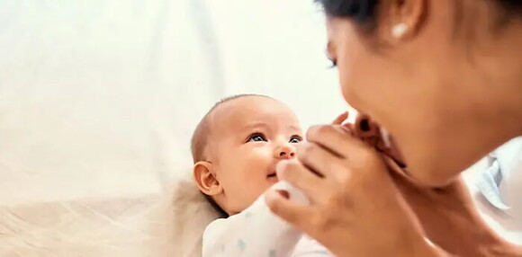 Mamá viendo a su bebé de tres meses estableciendo vínculos.