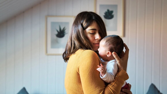 Mamá cargando a su bebé de un mes.